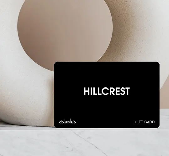Black Hillcrest Plus gift card leaning against a white sculpture on marble