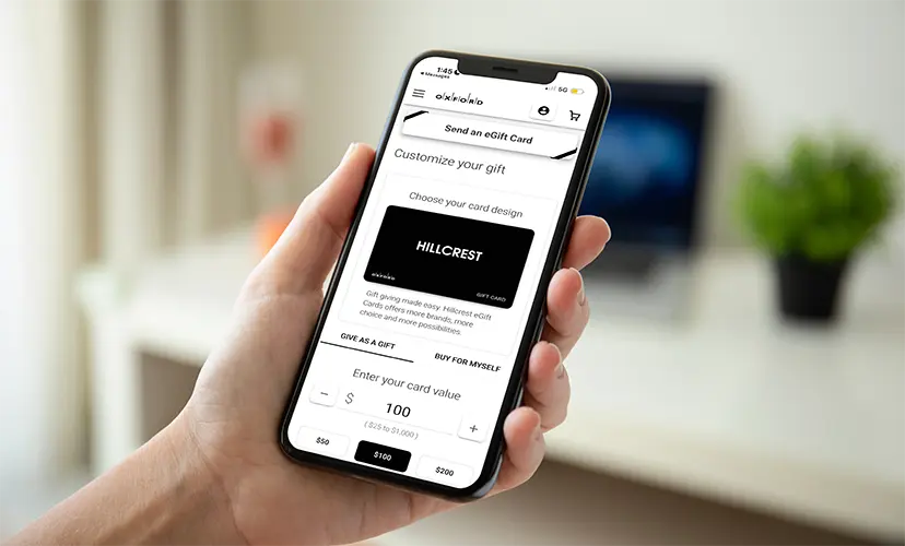 Hand holding a phone on the Hillcrest eGift card design and value screen