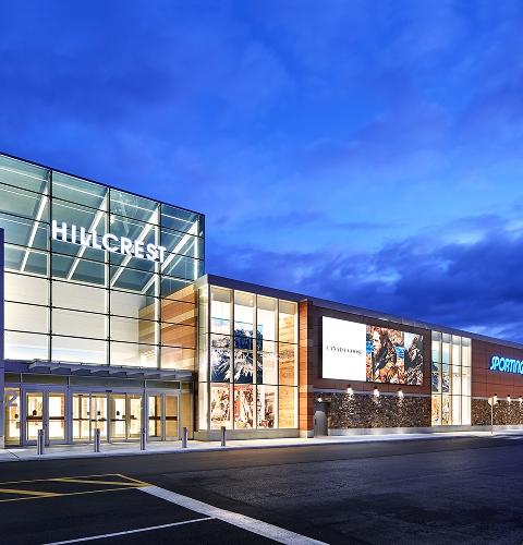 Lit Hillcrest mall exterior at dusk with a Canada Goose ad panel