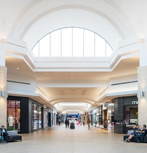 Mall concourse lined with Aritzia and Michael Hill and seating areas