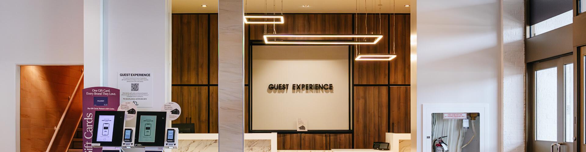 Guest Experience desk with gift card kiosks and warm wood panelling