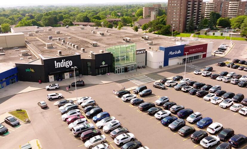 Aerial view of mall exterior with Indigo, Starbucks, Marshalls and full lot