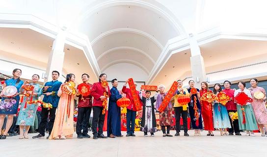 People in traditional dress holding red banners at a Lunar New Year event