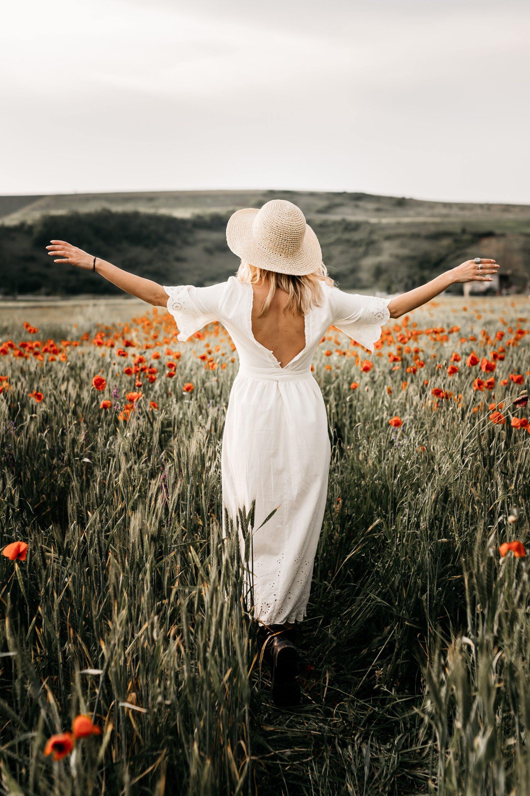 Girl in a white dress walking through a field