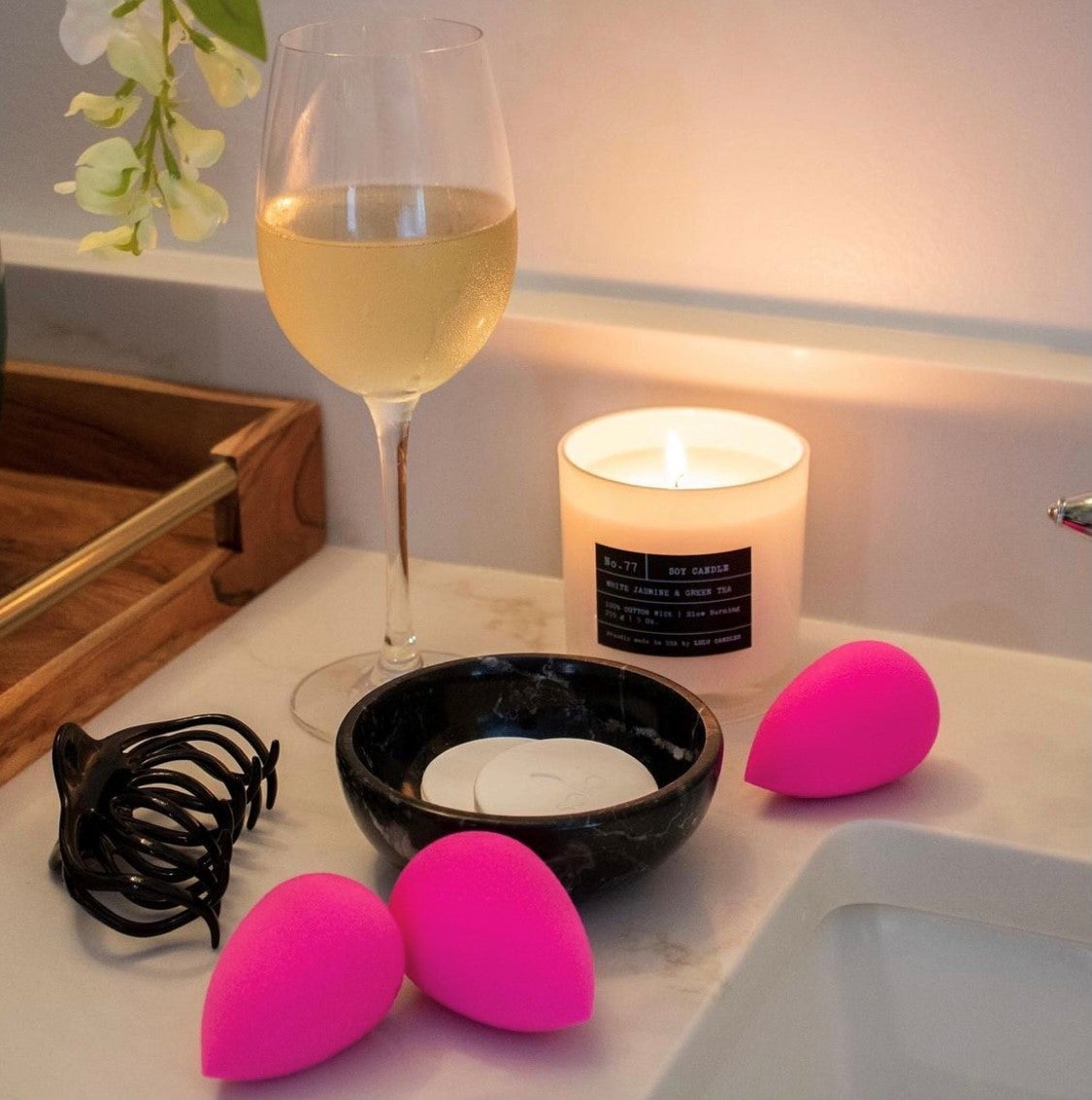 beauty blenders surrounded by candles and wine