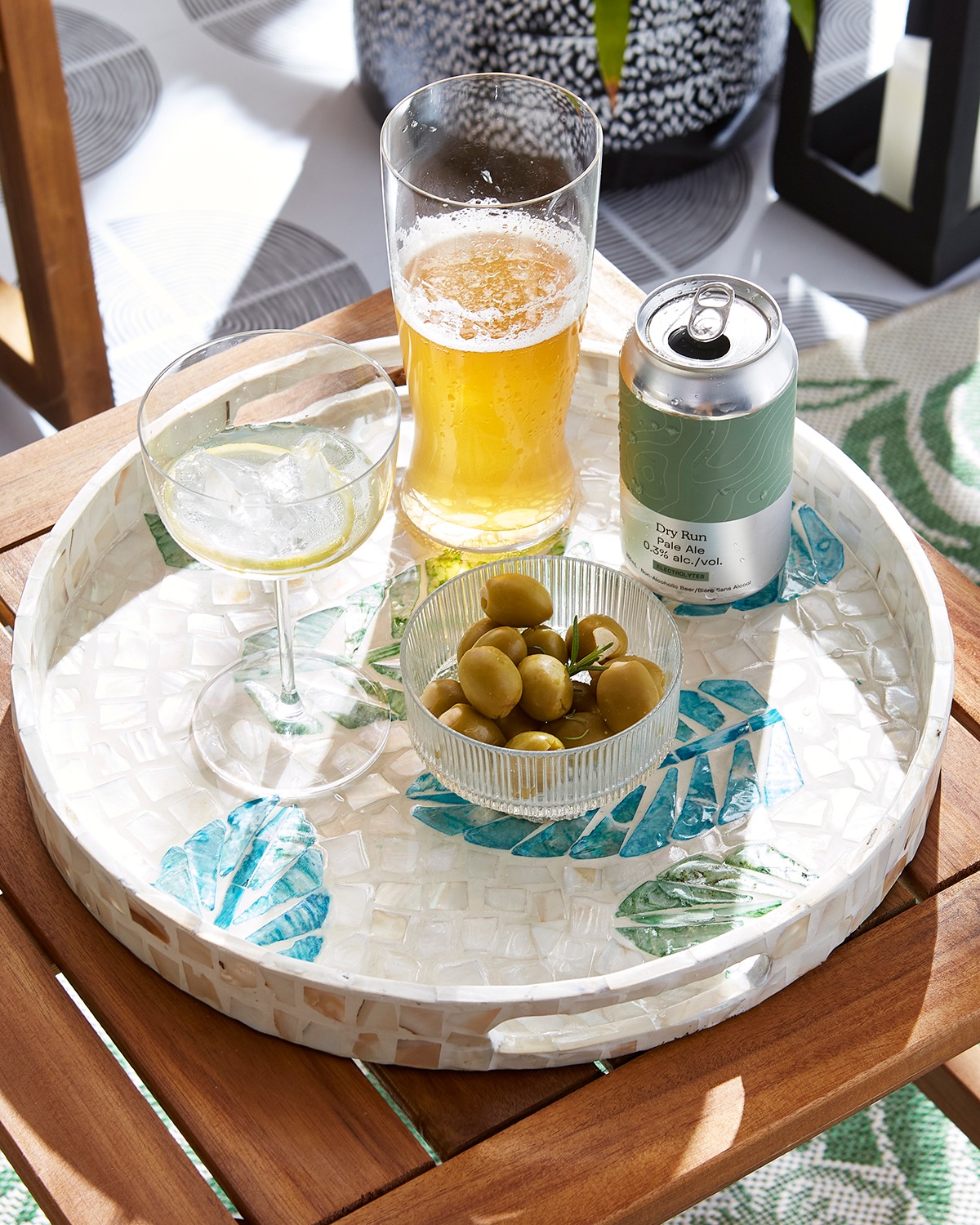 On top of a tropical themed drink tray sits olives and drink ware from HomeSense.