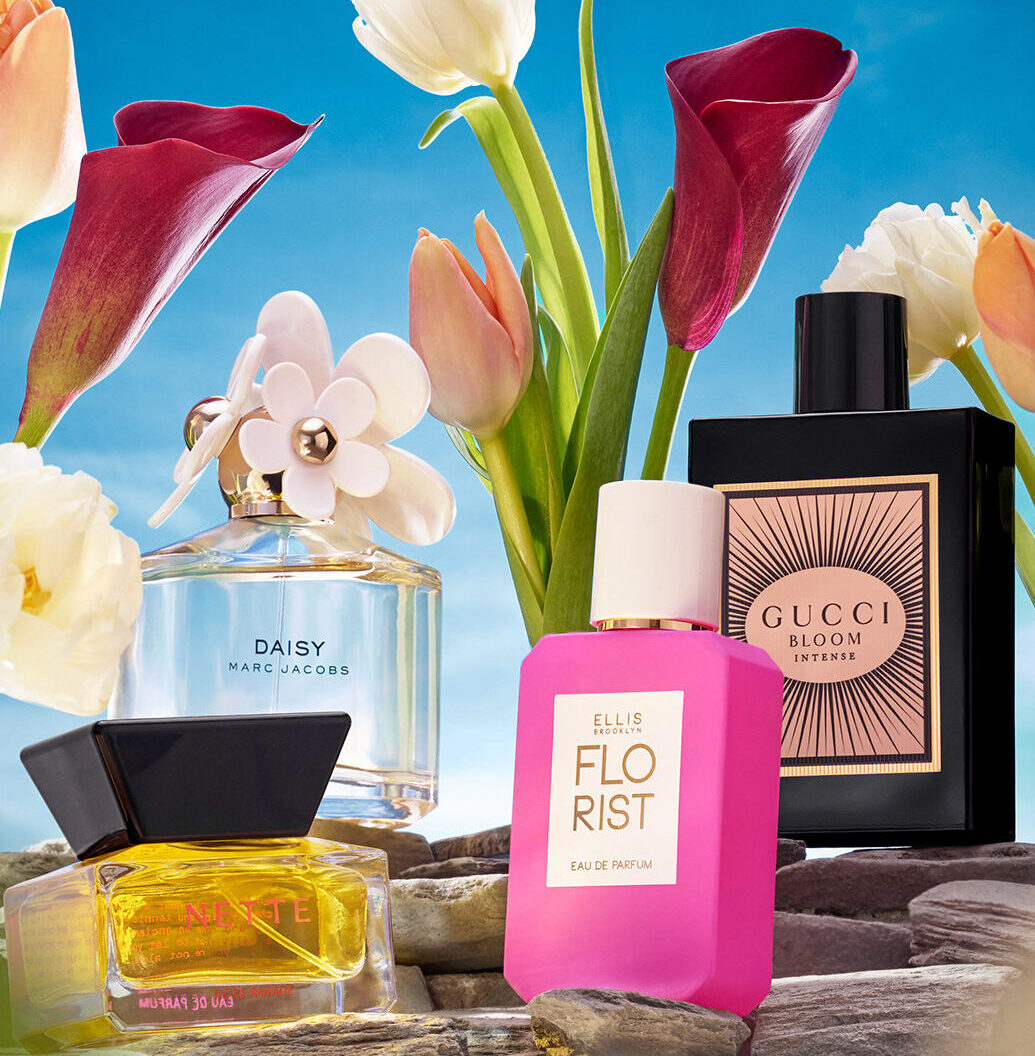 Four perfumes from Sephora are on display in front of beautiful, spring-time flowers.
