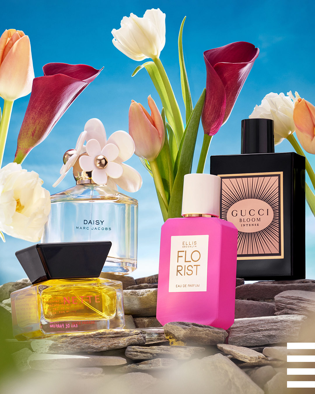 Four perfumes from Sephora are on display in front of beautiful, spring-time flowers.