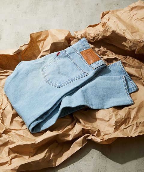 a pair of light wash levi's jeans folded atop brown packing paper