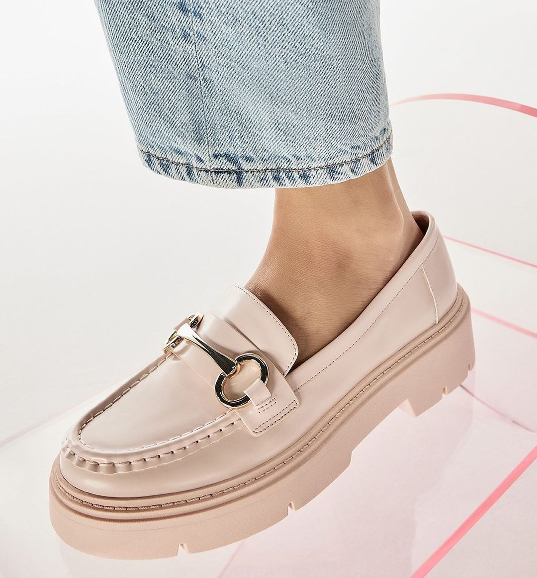 single pink loafer worn by a model