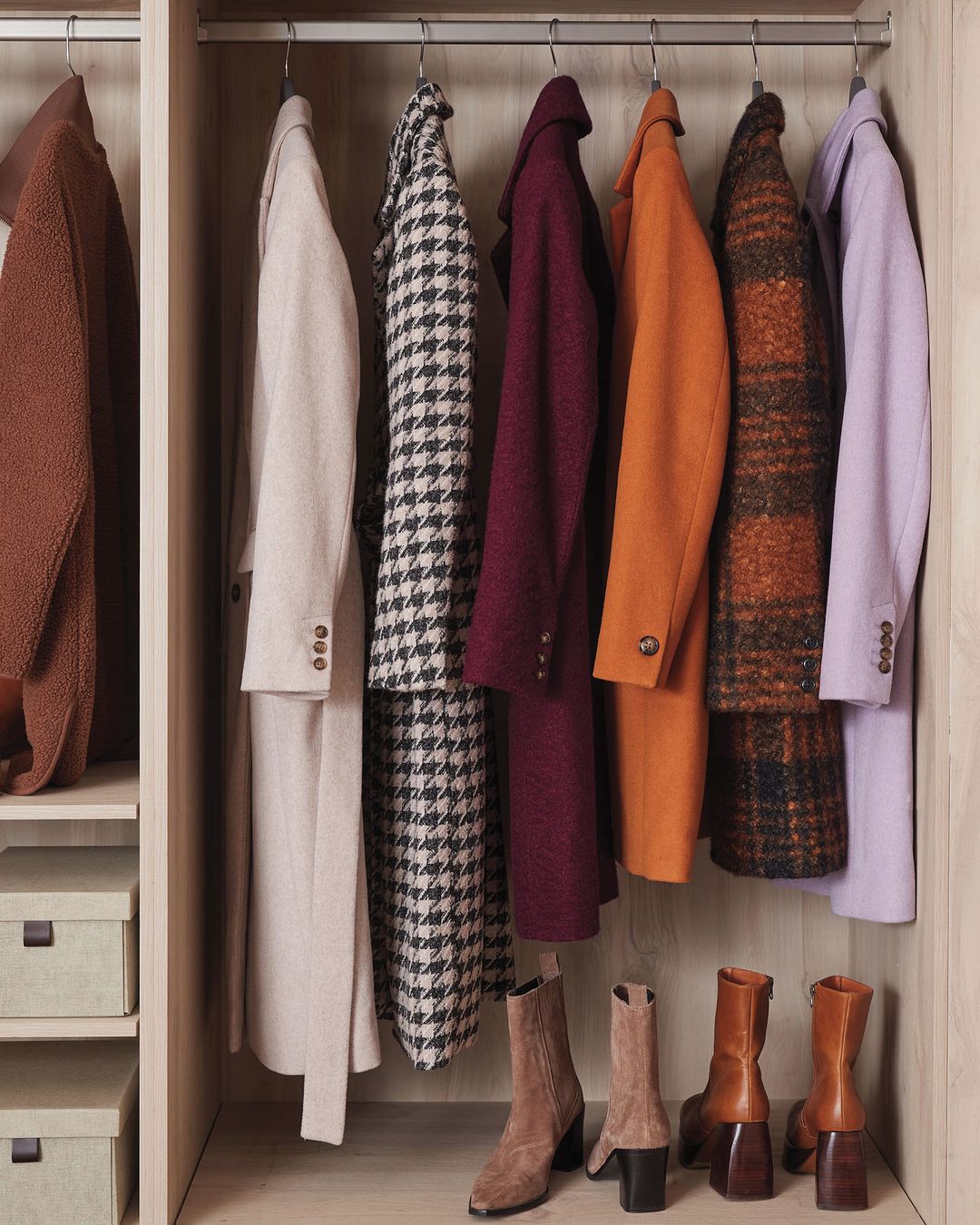 Line up of five coats hanging in a closet.