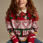 Girl wearing holiday sweater.