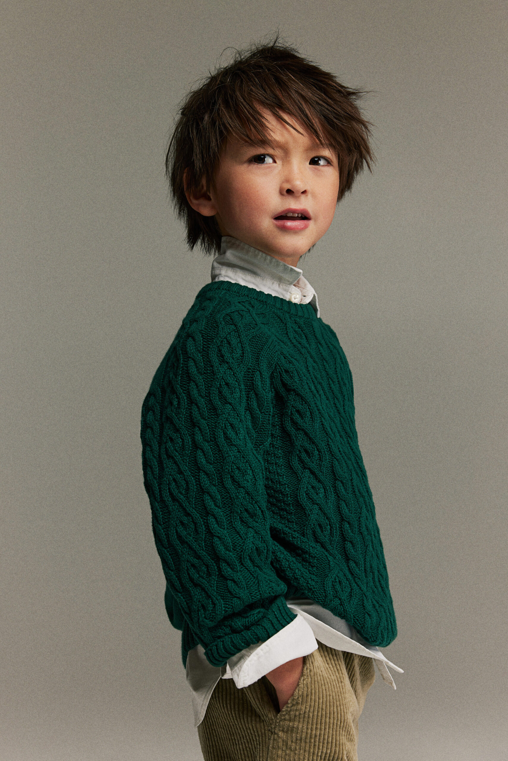 Boy wearing forest green knit sweater from H&M.