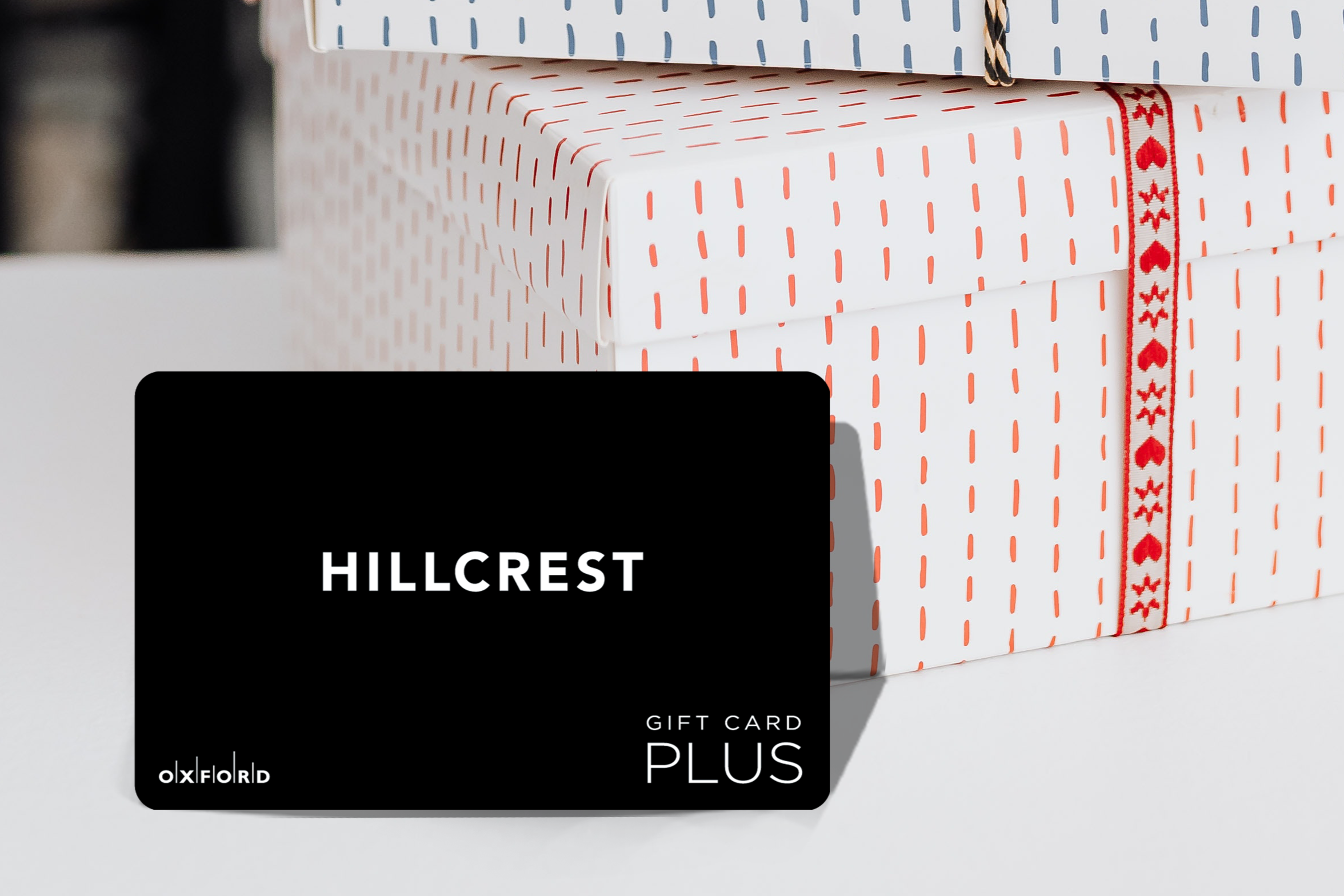 promotional image of a black Hillcrest gift card in front of two gift boxes