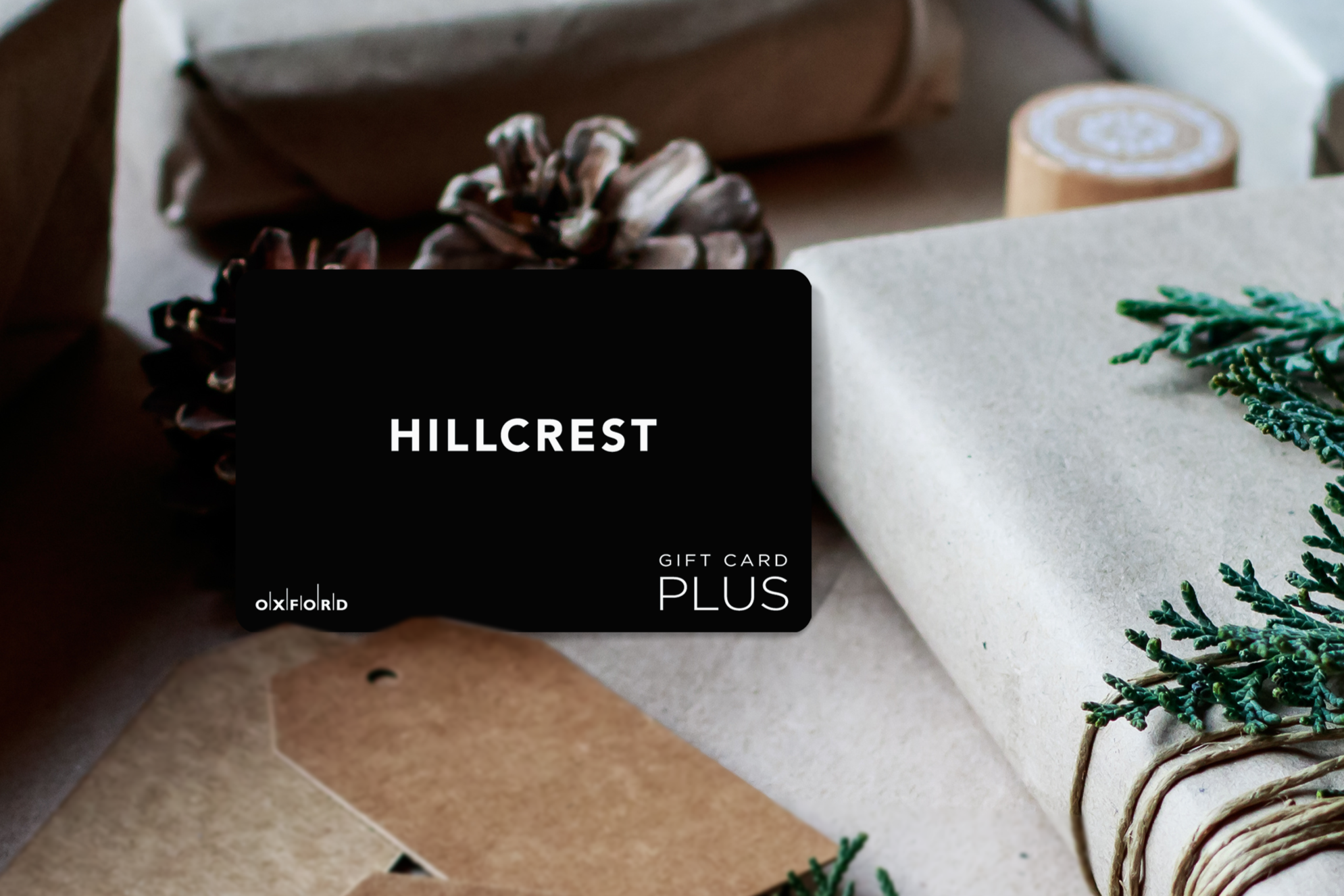 promotional image of a hillcrest gift card surrounded by gift-wrapped books in a holiday setting