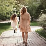 Woman and girl walking on paved path
