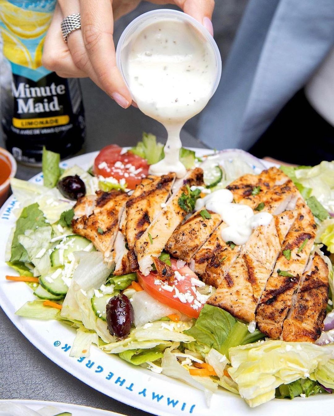 Pouring sauce over chicken salad from Jimmy the Greek