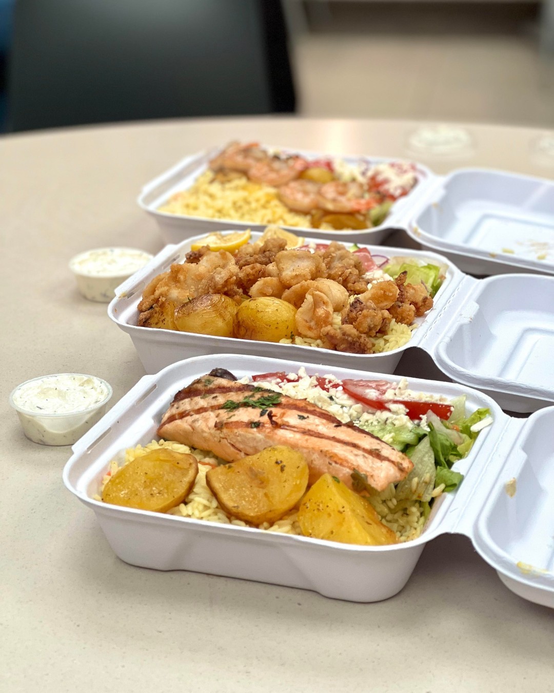 Takeout containers with rice, potatoes, and salmon from Jimmy the Greek