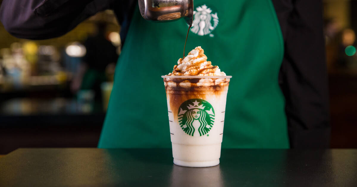 Barista pouring toppings over drink from Starbucks