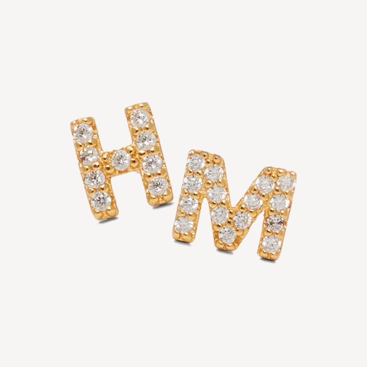 Gold earring studs in shape of letters H and M