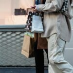 Man holding shopping bags outside.