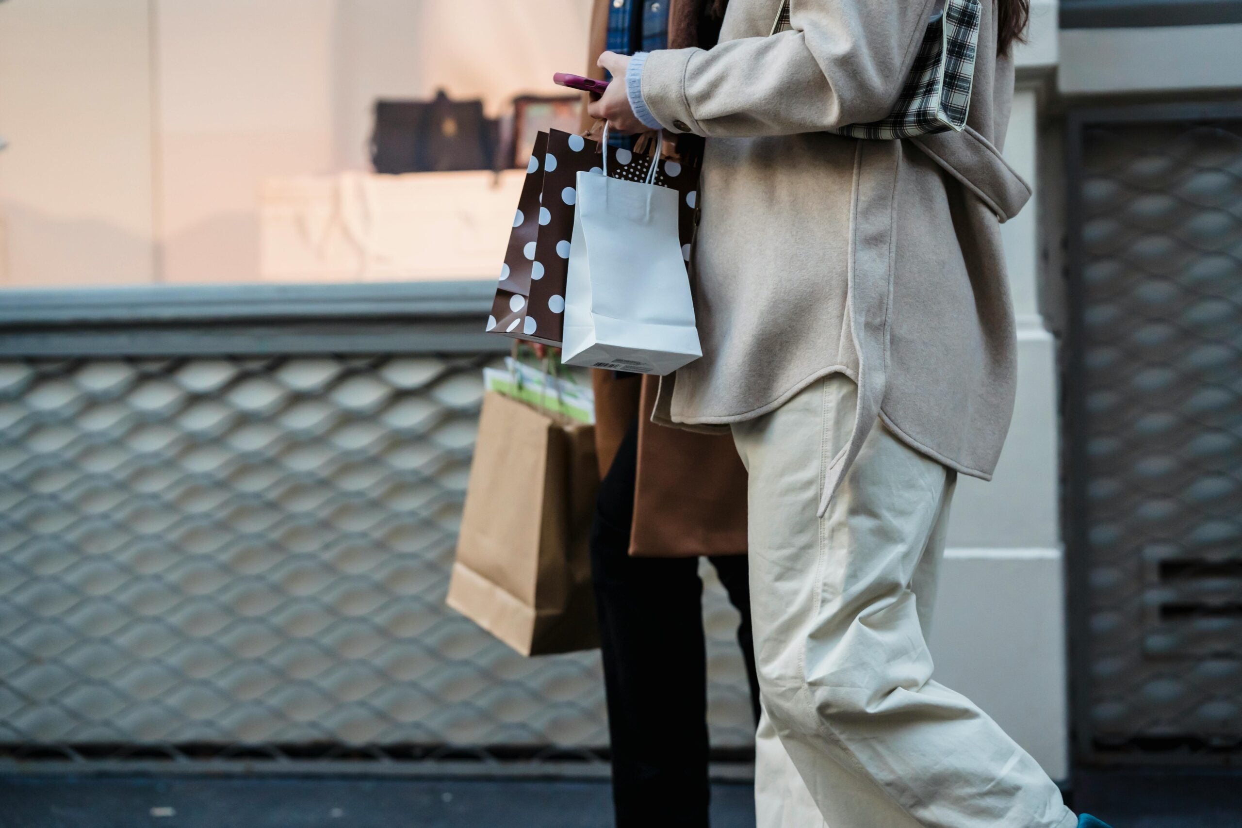 Man holding shopping bags outside.